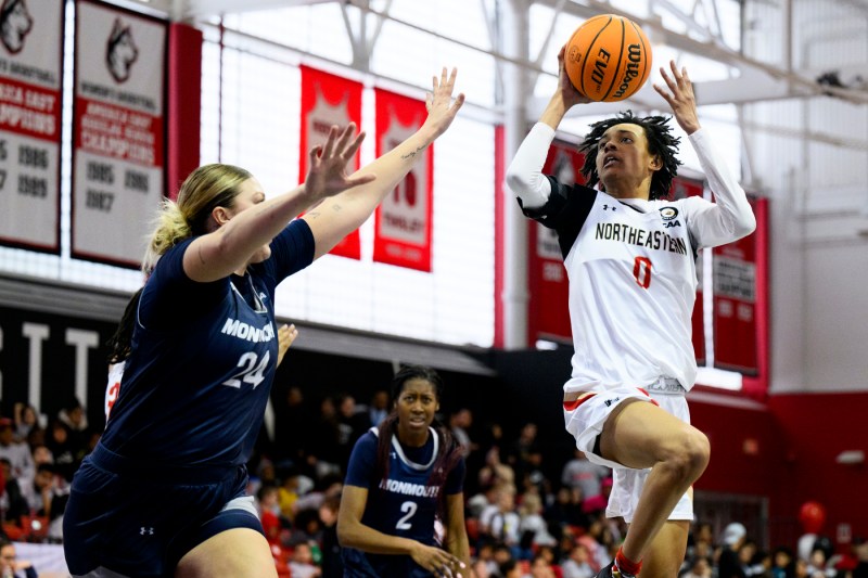 Norhteastern basketball player shooting the ball.