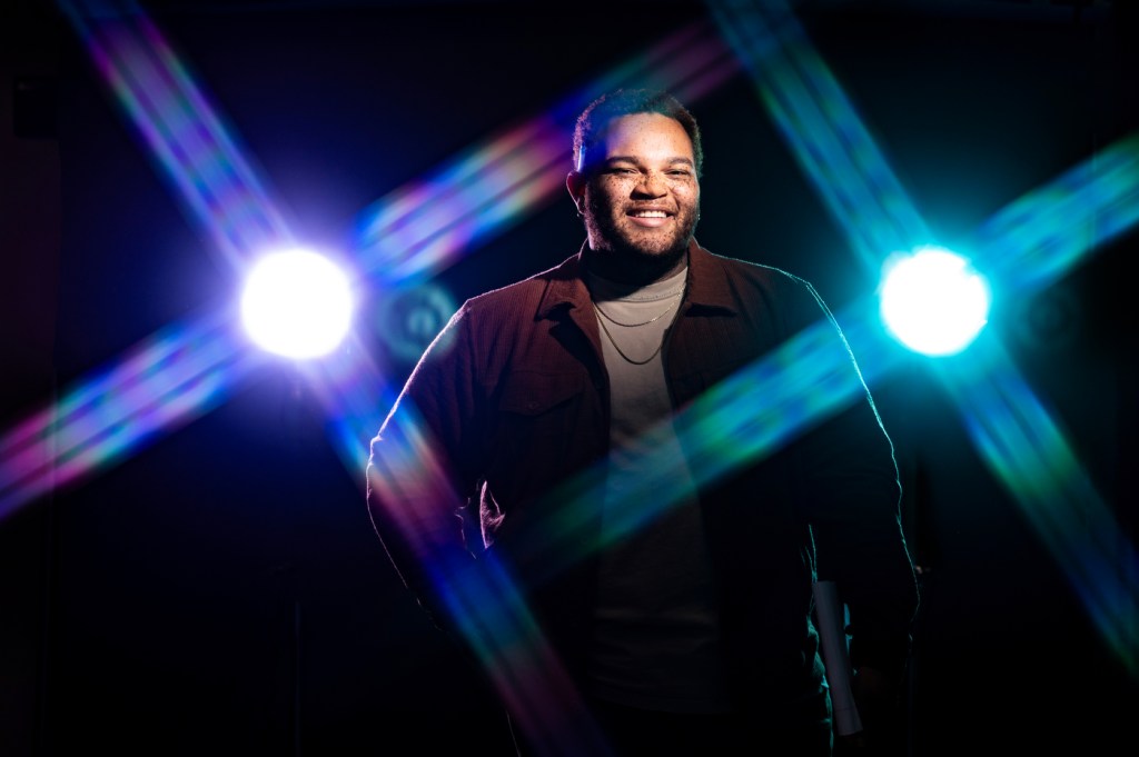 Donovan Holt posing in front of studio lights.