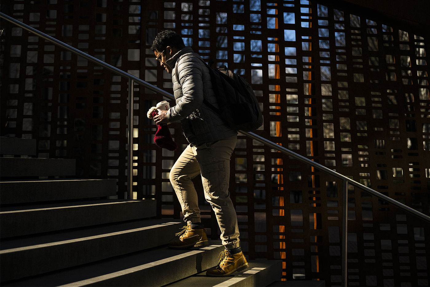A person climbs the stairs outside on a sunny day.
