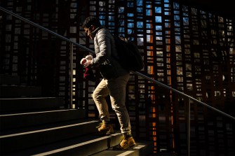 A person climbs the stairs outside on a sunny day.