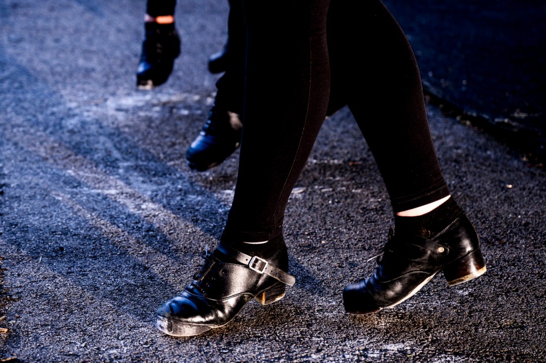 Three people dance while wearing heavies and black leggings.