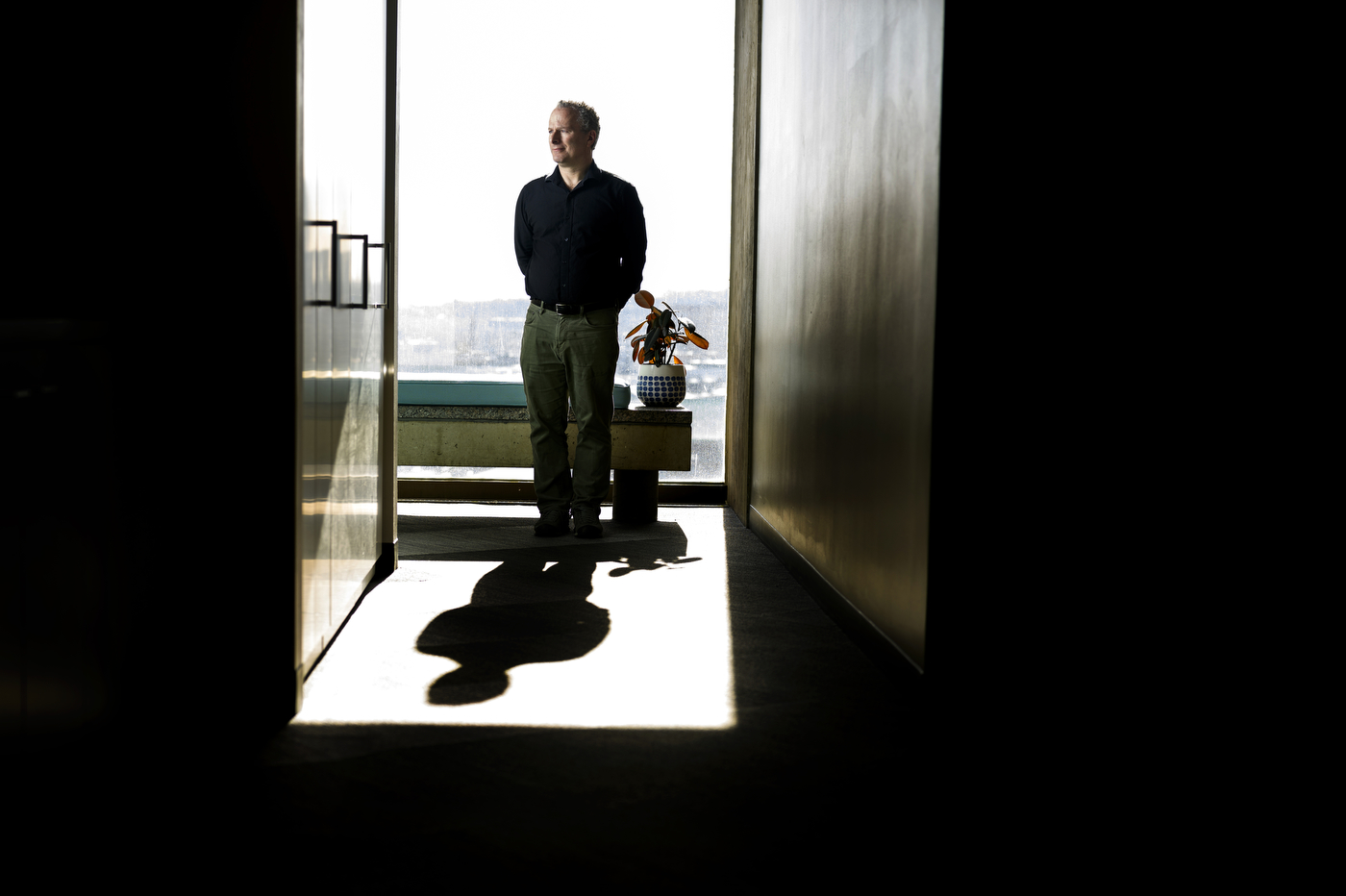 David Lazer stands in a doorway, surrounded by shadows.