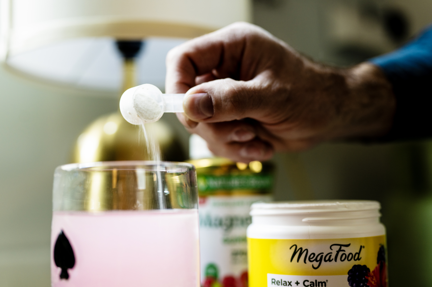 A hand pours powdered magnesium into a cup.