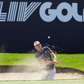 A golfer hits a gold ball out of a sand pit during a tournament in Saudi Arabia.