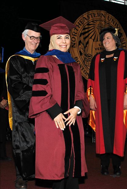 Kholoud Khateeb wearing a cap and gown at Northeastern graduation.