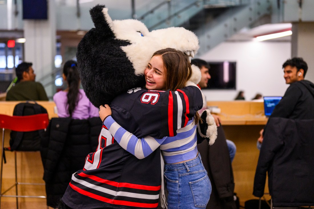 A student hugs Paws