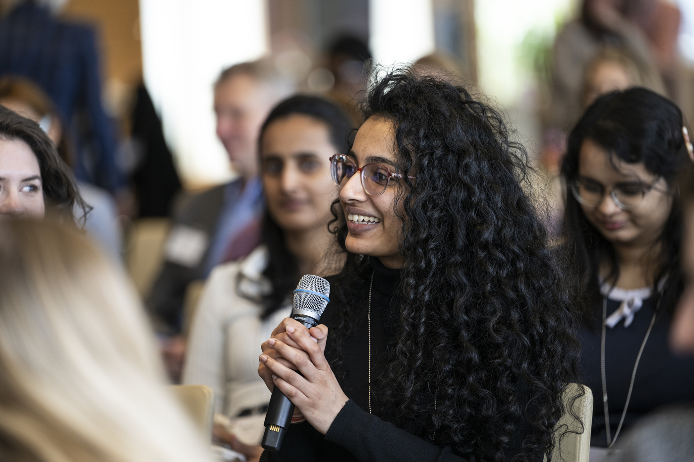 Audience member speaking into a microphone at Women Who Empower event. 