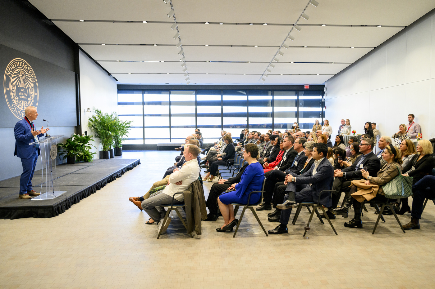 David De Cremer speaking in front of a room full of people.