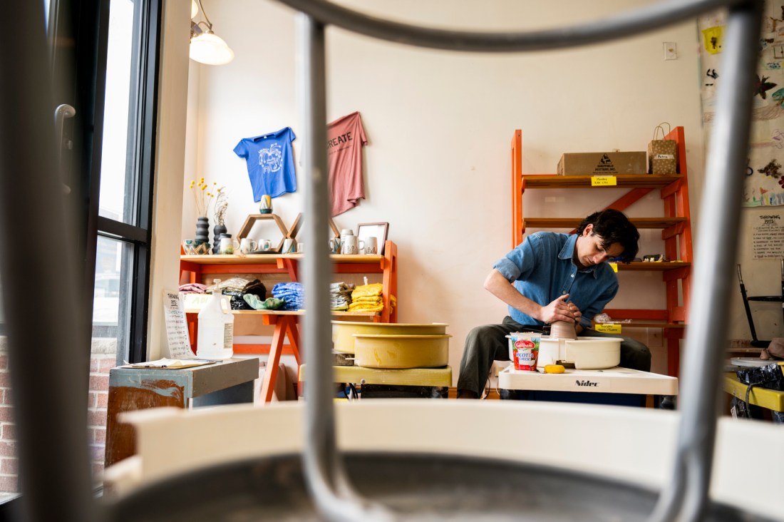 David Chatson throwing pottery on a wheel in their studio.