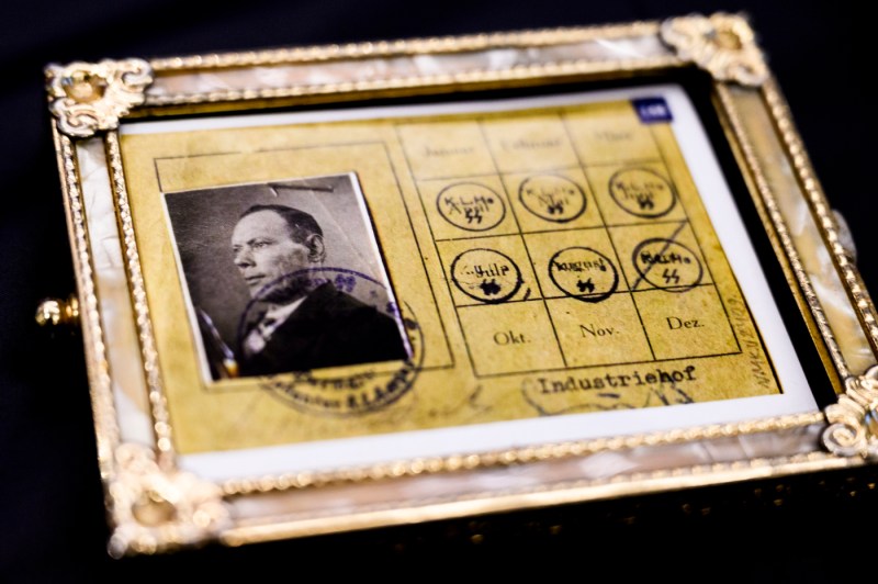 A Holocaust survivor's identification card in a gold-colored picture frame.