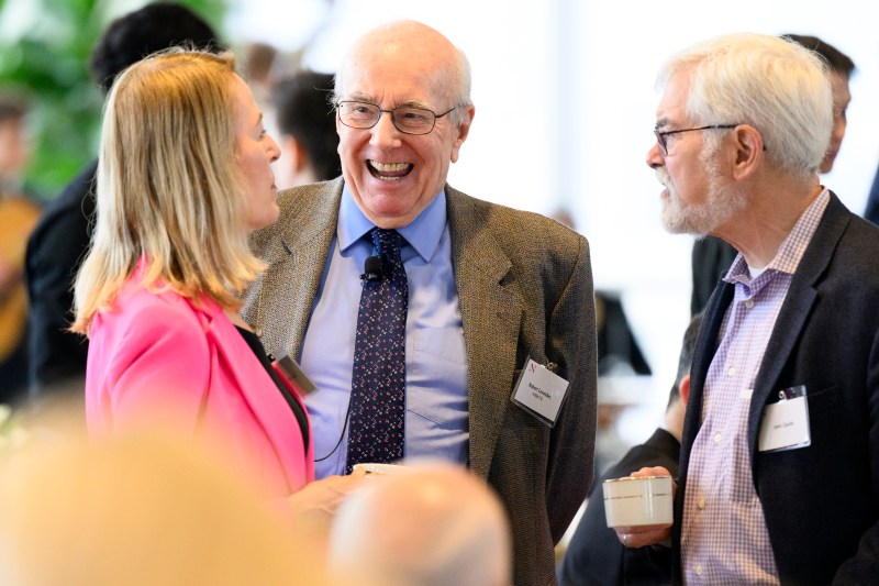 Three Northeastern employees talking and laughing with each other.