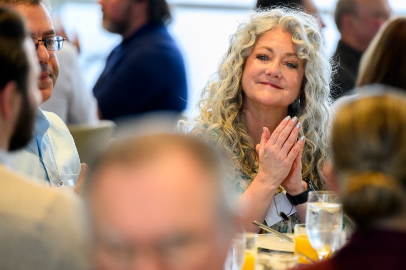 A Northeastern employee smiling while clapping their hands.