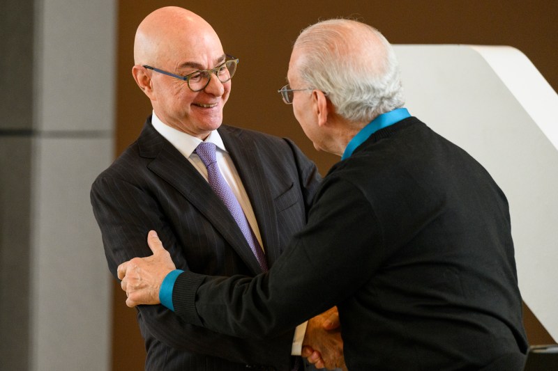 Joseph Aoun giving a warm handshake to a Northeastern employee. 