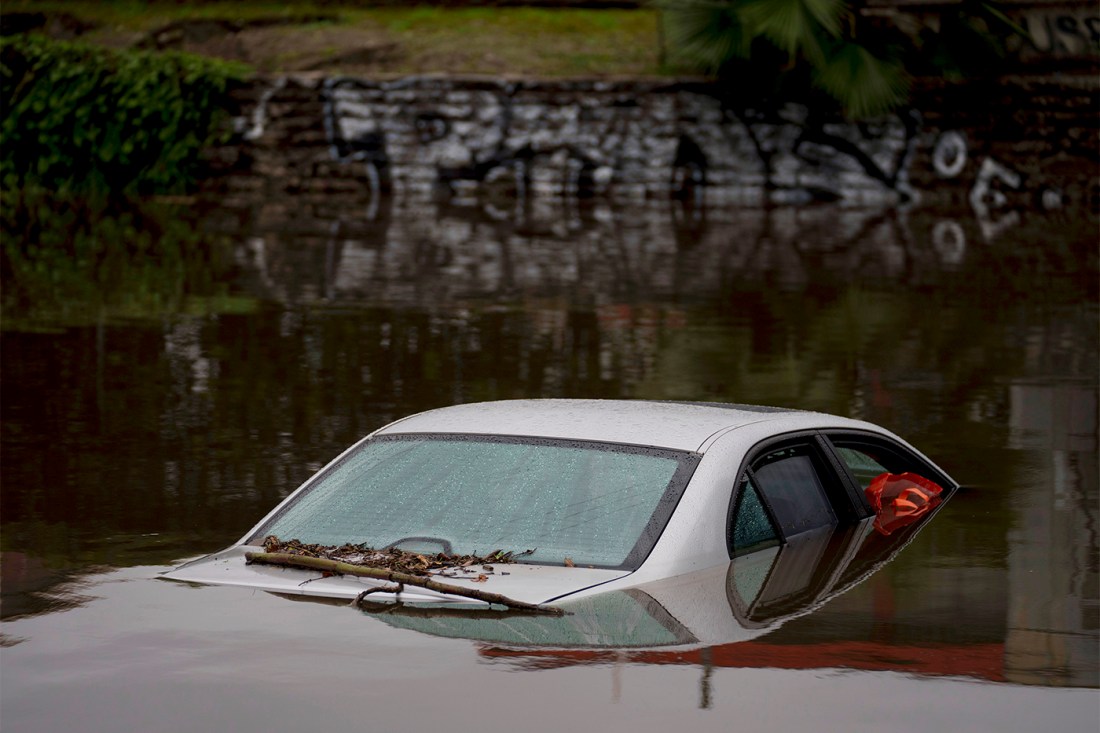 A silver car submerged in water.