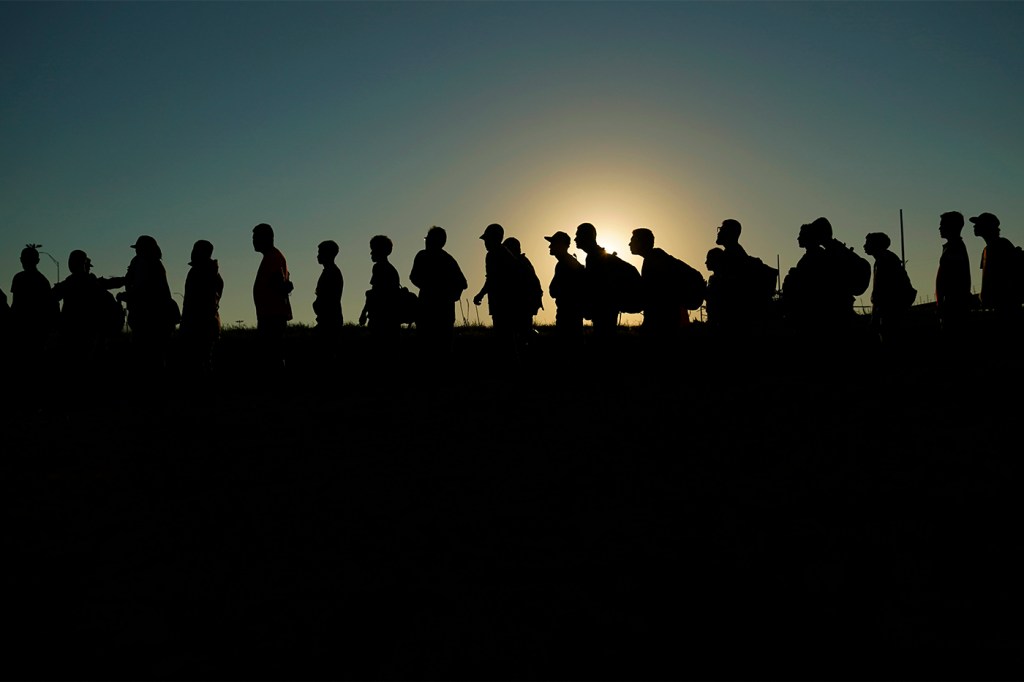 Silhouette of migrants lined up for processing in Texas.