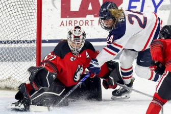 Northeastern womens goalkeeper saving a shot by UConn.