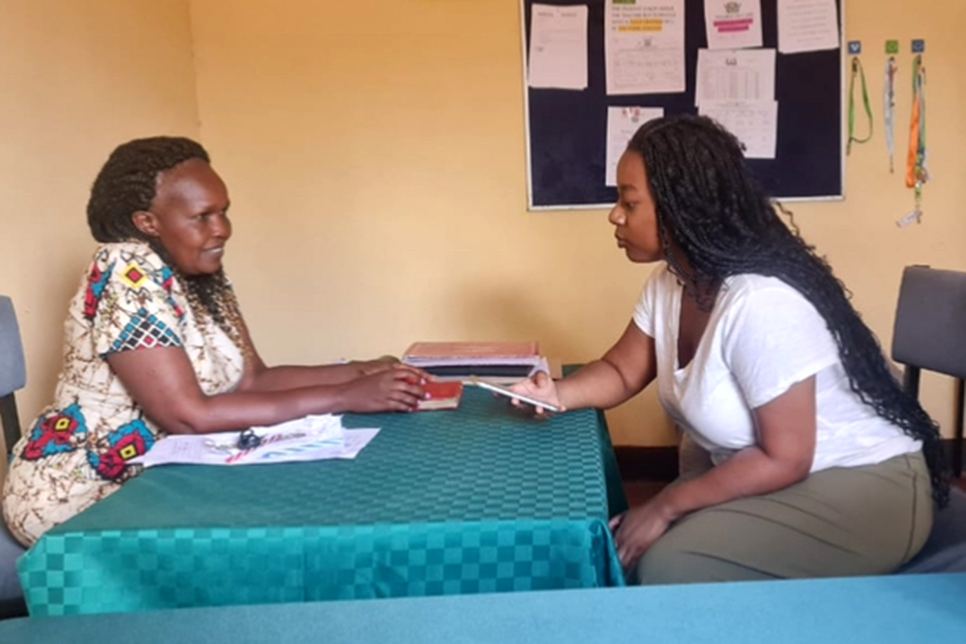 Leah Oruko speaking with a woman in Africa.