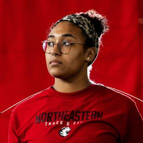 Headshot of Liangie Calderon wearing a red Northeastern Track & Field t-shirt.