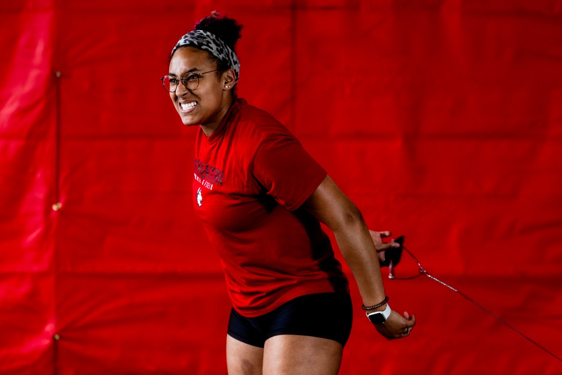 Liangie Calderon gritting her teeth as she prepares to throw a hammer.