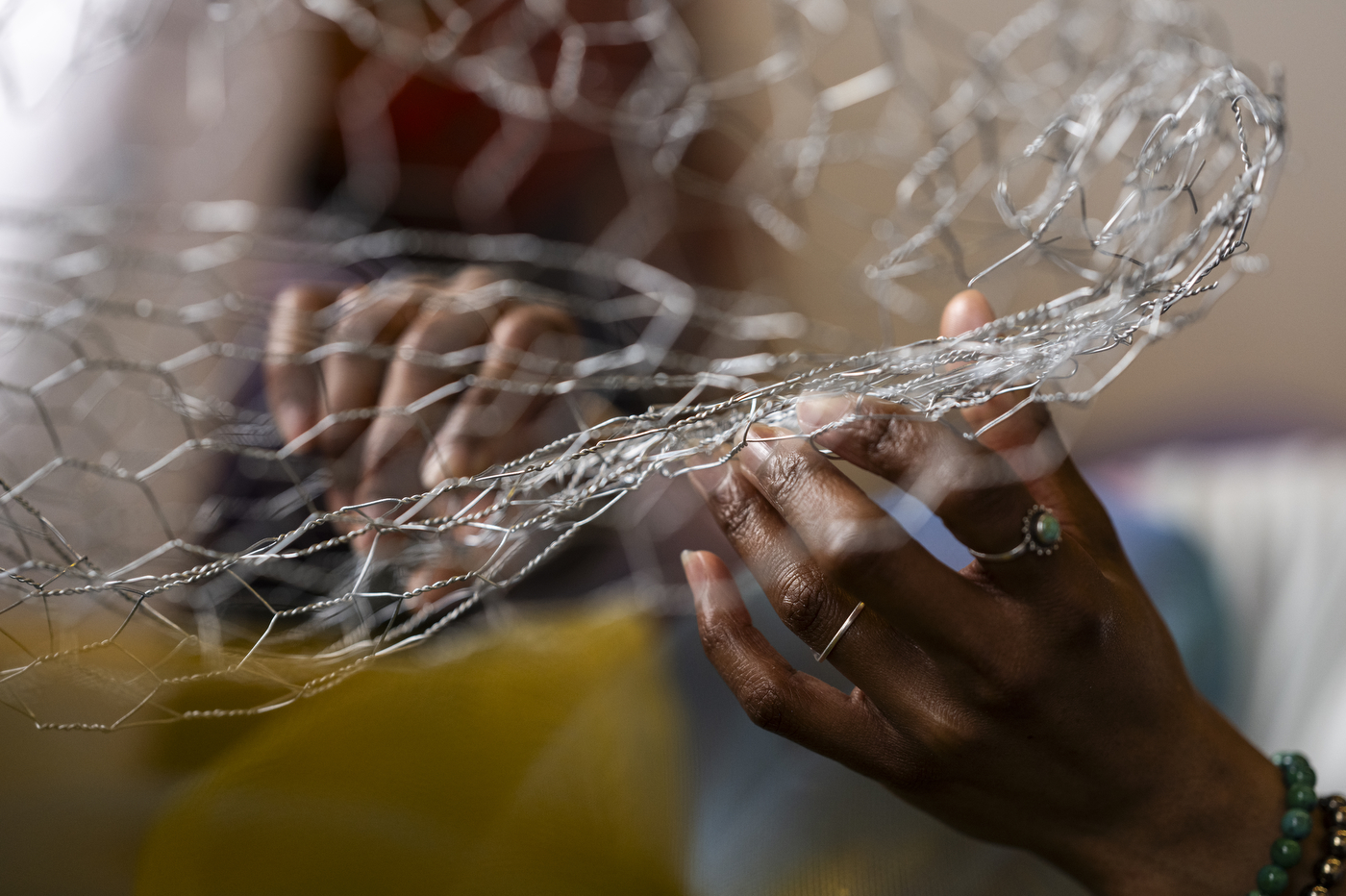 Cicley Carew manipulating steel wire for abstract art installation.