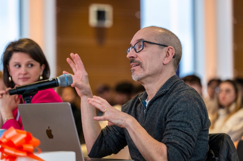 A panel judge speaking into a microphone.