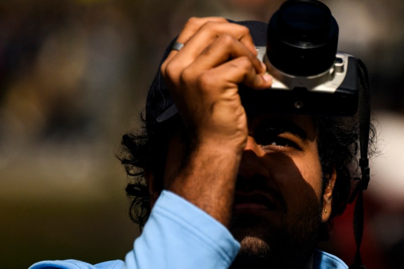 A person using a camera to take a photo of the solar eclipse. 