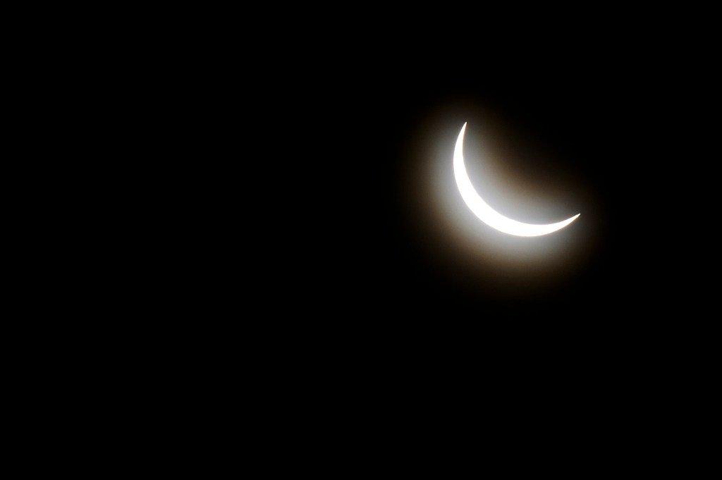 The sun mostly covered by the moon in a solar eclipse.