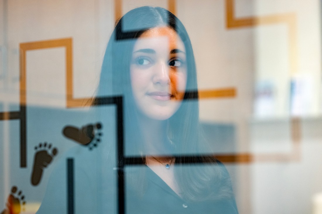 Headshot of Isabella Rando taken through a window. 