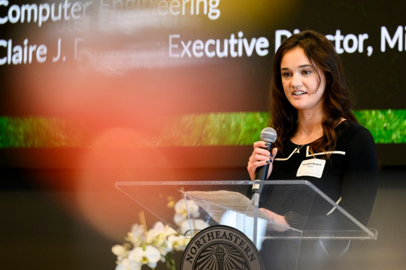 A person speaking into a microphone at the rededication of the Center of STEM education.