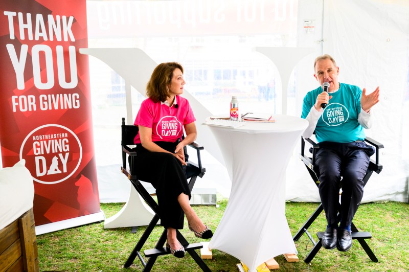 Diane Nishigaya MacGillivray and another person wearing giving day branded t-shirts sitting together and speaking into microphones.