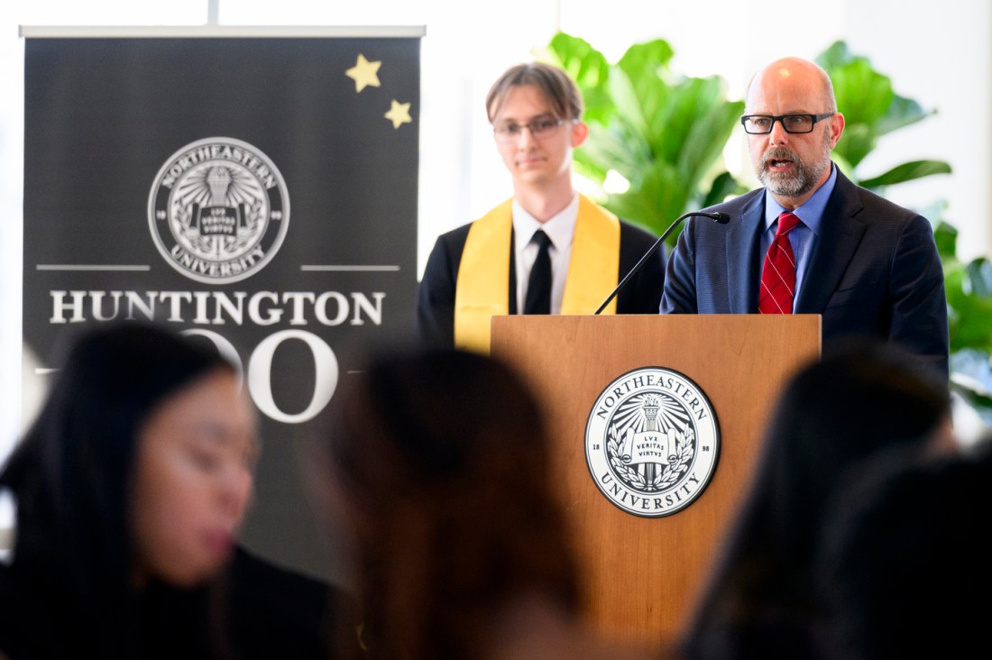 A person speaking at a podium at the Huntington 100. 