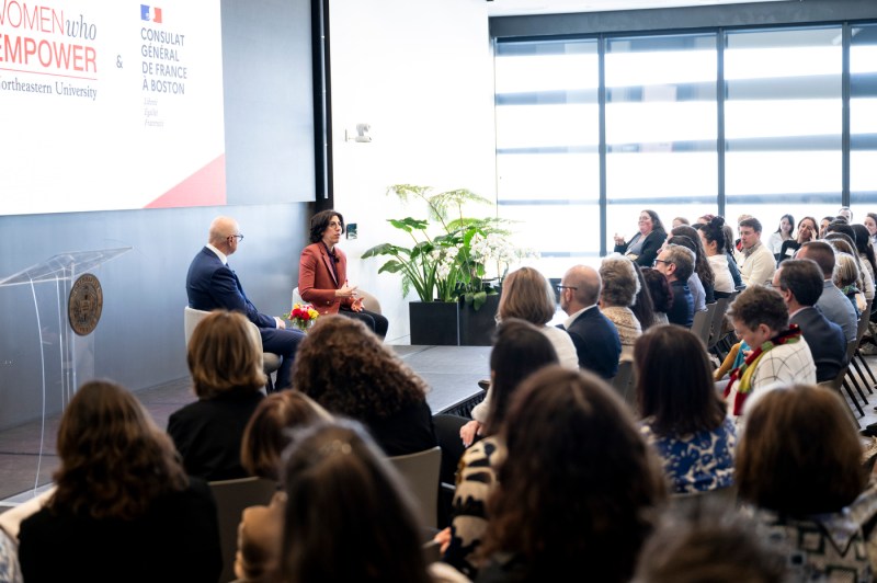 Room full of audience members listening to Rima Abdul Malak and President Joseph E Aoun who are both sitting on stage.