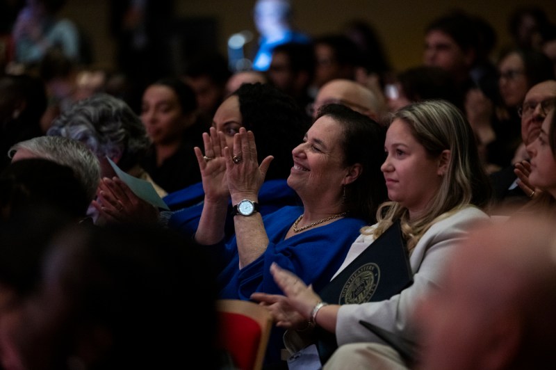 Audience members clapping and smiling at the Academic Honors Convocation. 