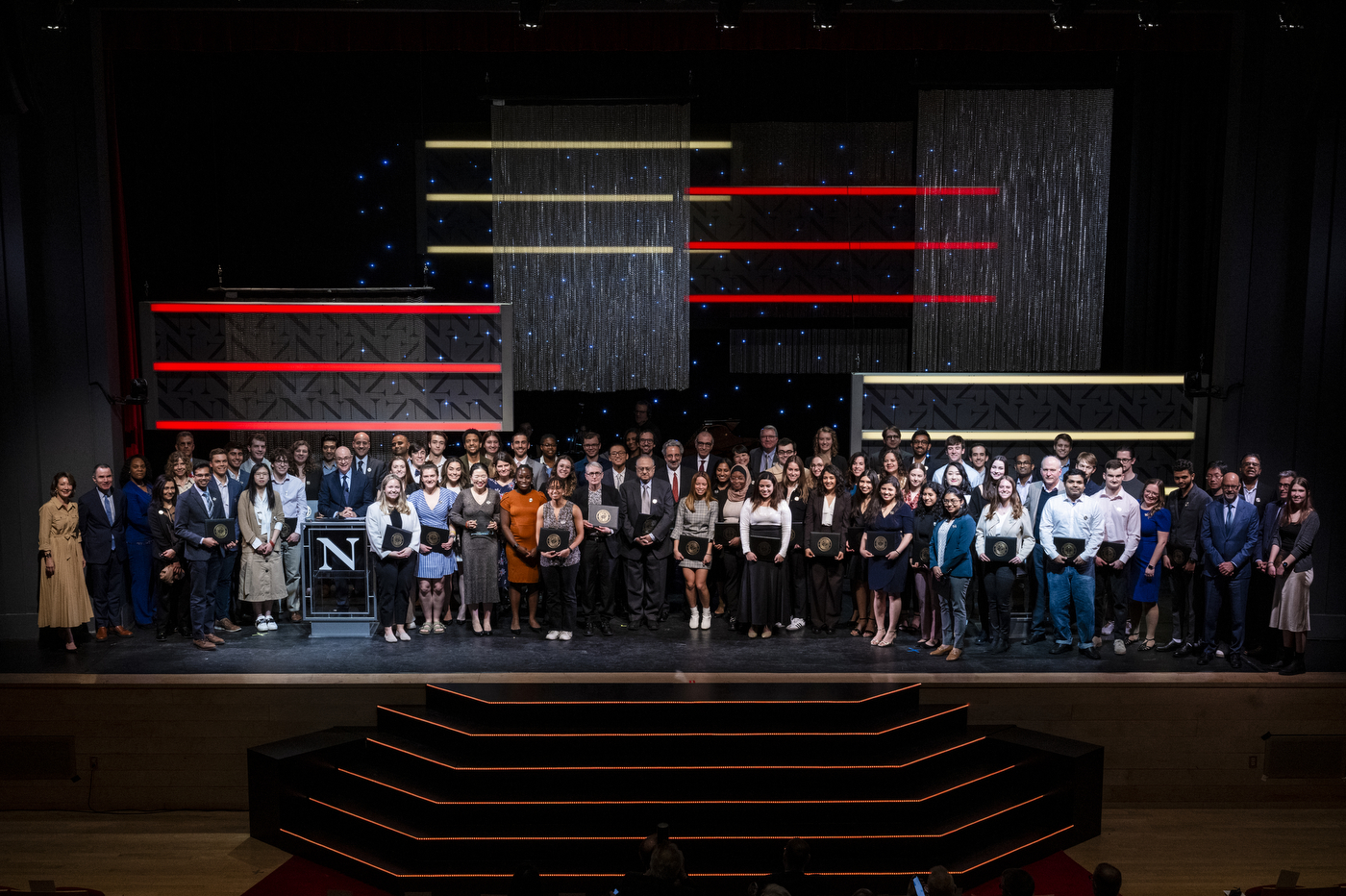 Students and faculty standing on stage at Blackman auditorium.