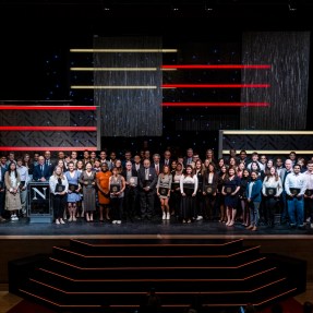 Students and faculty standing on stage at Blackman auditorium.