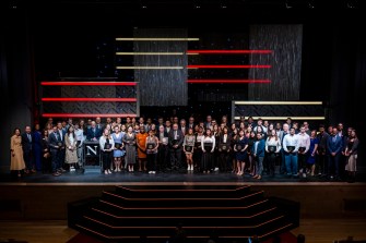 Students and faculty standing on stage at Blackman auditorium.