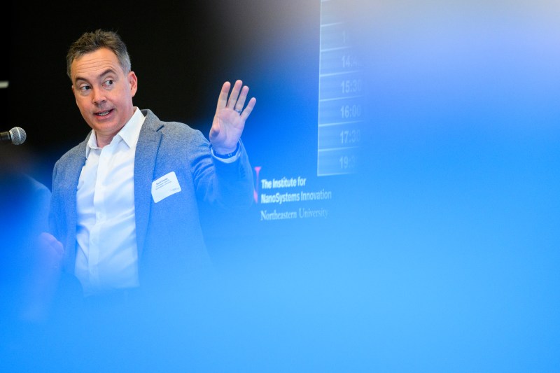 David Horsley speaking into a microphone and gesturing with his left hand.