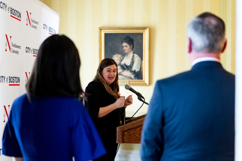 A Moakley scholar speaks at a microphone at the reception. 