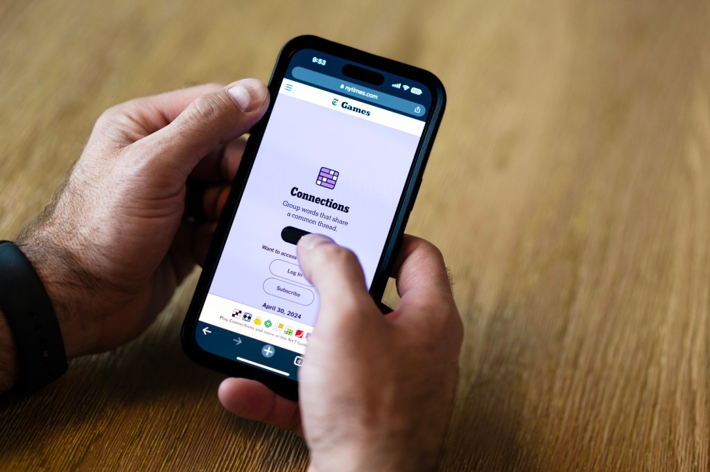 Person holding their phone open to a NYTimes game screen.