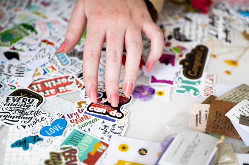 Student sorting through stickers to decorate their graduation cap with.