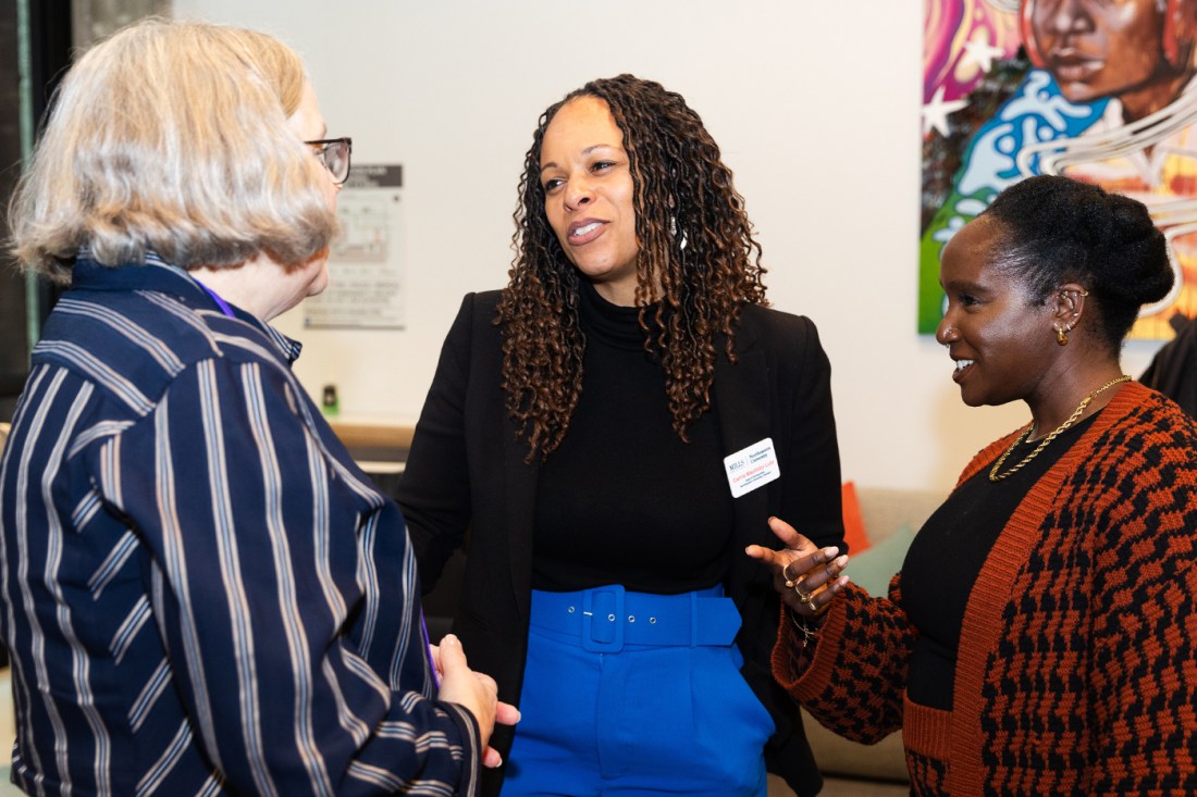 Three people talking and smiling.