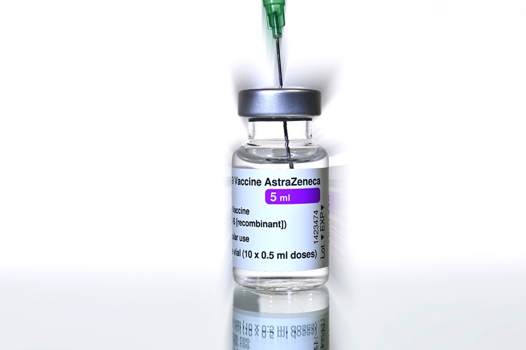 A vial of AstraZeneca vaccine with a syringe in it.