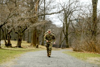 Kayla McCann running in her uniform with a weighted rucksack.