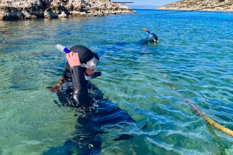 Francesca Russell in the water off the coast of Greece wearing scuba diving gear.