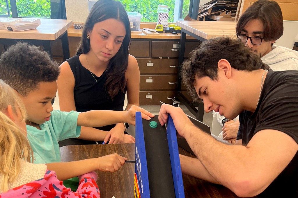 Students testing a toy built by an engineering student.