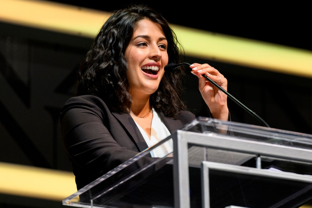 Kritika Singh smiling while speaking into a microphone.