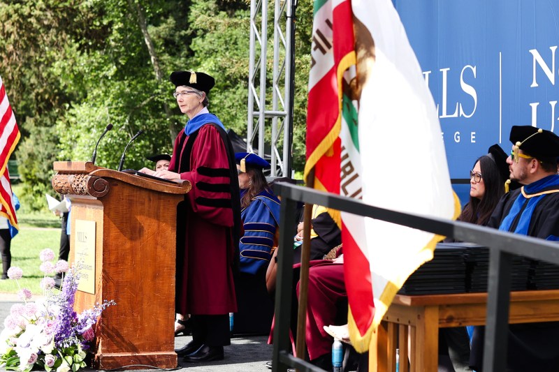 A person speaks at a podium at Northeastern's Oakland commencement.