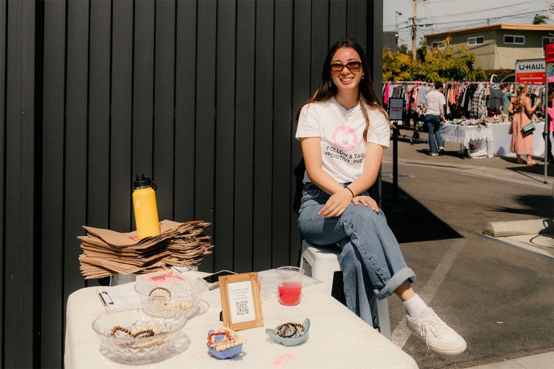 Nicole Lee sitting outside in jeans and a white t-shirt. 