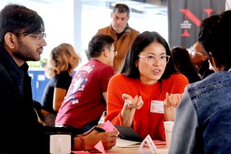 Three people speaking to each other and gesturing at the Start Summit.