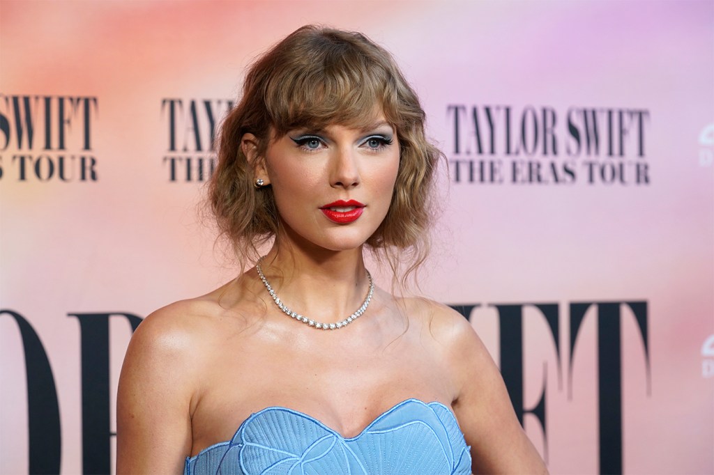 Taylor Swift at the premiere of the Eras Tour concert film wearing a blue dress.